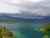 Teluk Tomori berair hijau toska dengan bukit berhutan dan permukiman tepi teluk, Morowali Utara