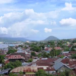 Atap-atap rumah Kota Ternate dengan teluk dan gunung di kejauhan
