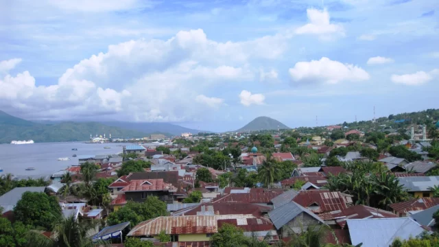 Atap-atap rumah Kota Ternate dengan teluk dan gunung di kejauhan