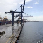 Derek dermaga dan truk pengangkut di terminal peti kemas Tanjung Priok, Jakarta