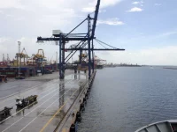 Derek dermaga dan truk pengangkut di terminal peti kemas Tanjung Priok, Jakarta