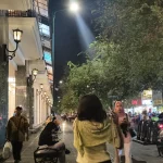 Orang berjalan di trotoar Malioboro Yogyakarta pada malam hari dengan lampu jalan menyala