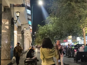 Orang berjalan di trotoar Malioboro Yogyakarta pada malam hari dengan lampu jalan menyala