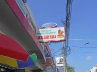 Papan nama pusat oleh-oleh khas Lampung Aneka Sari Rasa di bawah langit biru