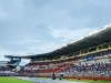 Tribune stadion penuh penonton di bawah lampu sorot