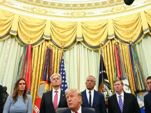 Donald Trump duduk dikelilingi sejumlah pejabat berjas gelap di Ruang Oval Gedung Putih