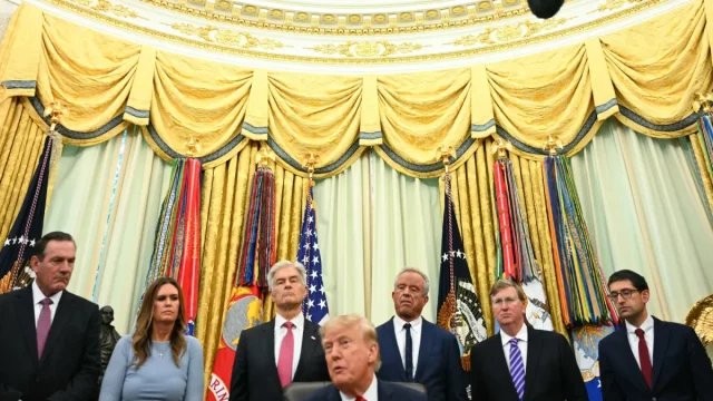 Donald Trump duduk dikelilingi sejumlah pejabat berjas gelap di Ruang Oval Gedung Putih