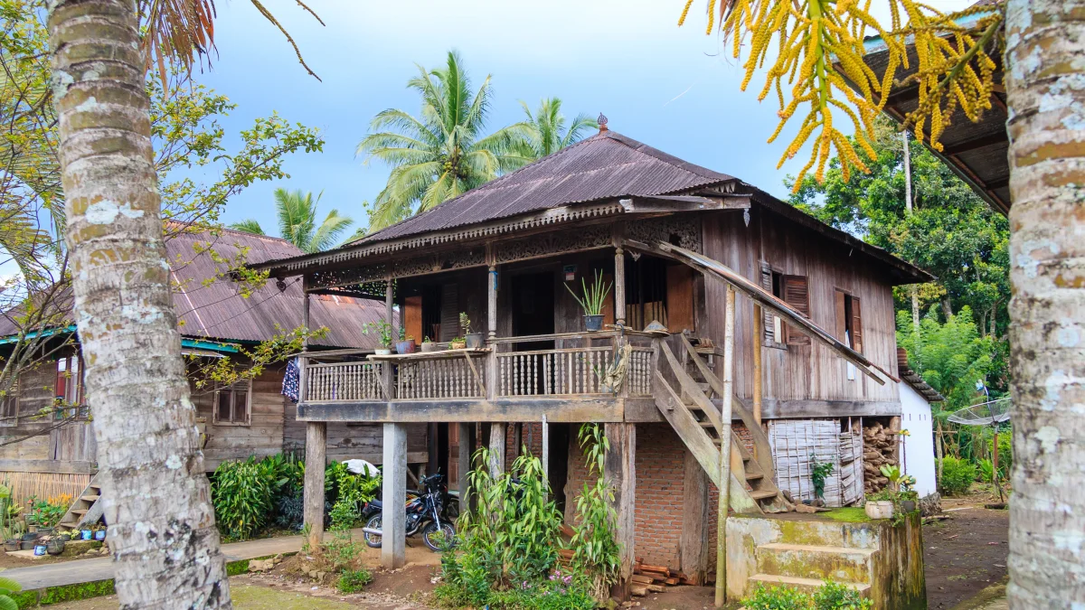 Rumah panggung kayu khas Rejang dengan tangga samping dan atap seng