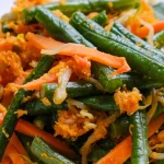 Urap kacang panjang, wortel, dan tauge berbalut kelapa parut berbumbu di atas piring putih