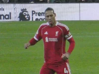 Virgil van Dijk berlari mengenakan seragam merah Liverpool