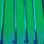 Permukaan wafer silikon berpola dengan kilau hijau dan biru