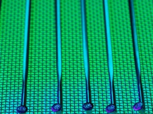 Permukaan wafer silikon berpola dengan kilau hijau dan biru