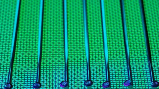 Permukaan wafer silikon berpola dengan kilau hijau dan biru