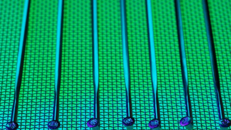 Permukaan wafer silikon berpola dengan kilau hijau dan biru