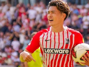 Penyerang Jepang SC Freiburg Yuito Suzuki memegang bola pertandingan seusai laga Bundesliga