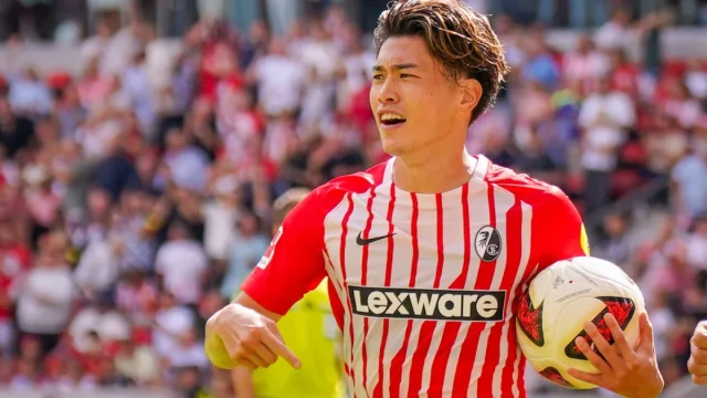 Penyerang Jepang SC Freiburg Yuito Suzuki memegang bola pertandingan seusai laga Bundesliga