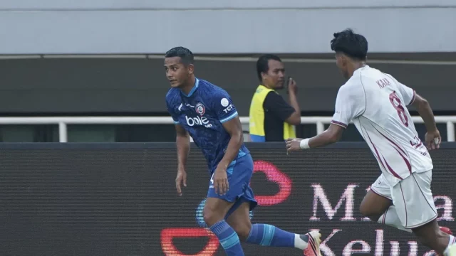 Pemain Arema FC berseragam biru dan pemain Garudayaksa FC berseragam putih di Stadion Pakansari