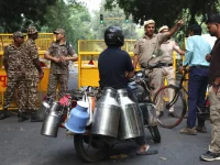 Petugas keamanan di depan barikade kuning mengarahkan warga di New Delhi, India