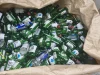 Ilustrasi tumpukan botol soju hijau kosong dalam karung daur ulang kaca di Korea Selatan