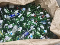 Ilustrasi tumpukan botol soju hijau kosong dalam karung daur ulang kaca di Korea Selatan
