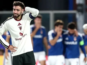 Bruno Fernandes memegang kepala saat pemain Como merayakan gol