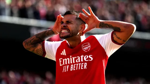 Bruno Guimaraes berseragam merah Arsenal merayakan gol dengan kedua tangan di samping kepala