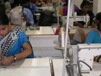 Ilustrasi buruh perempuan menjahit dengan mesin jahit industri di pabrik garmen di Bangladesh