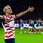 Cavan Sullivan merentangkan kedua tangan di lapangan dengan seragam bergaris merah putih timnas Amerika Serikat
