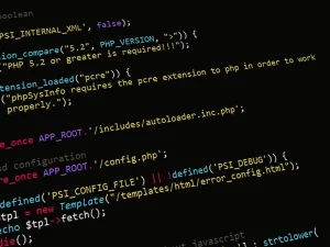 Potongan kode pemrograman PHP berwarna di layar monitor berlatar gelap
