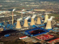 Menara pendingin dan cerobong PLTU Junliangcheng di Tianjin, Tiongkok, mengepulkan asap, dipotret dari udara
