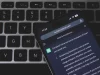 Ponsel menampilkan percakapan dengan chatbot AI di atas papan ketik