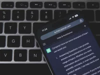 Ponsel menampilkan percakapan dengan chatbot AI di atas papan ketik