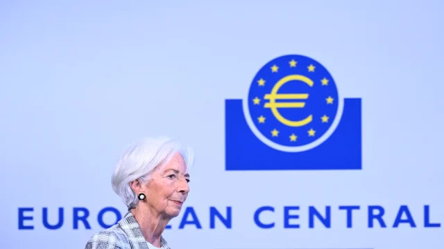 Presiden ECB Christine Lagarde berjalan di depan logo Bank Sentral Eropa