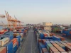 Hamparan peti kemas berwarna dan deretan derek jingga di terminal pelabuhan saat pagi