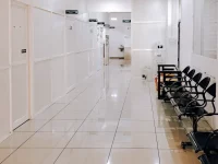 Ilustrasi lorong rumah sakit dengan deret kursi tunggu hitam yang kosong