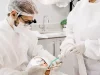 Ilustrasi dokter gigi bermasker bersama asisten menangani gigi pasien yang berbaring