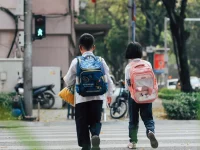 Ilustrasi dua anak beransel sekolah menyeberang di zebra cross jalan kota