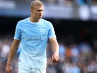 Erling Haaland berseragam biru muda Manchester City berjalan di lapangan