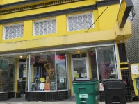Ilustrasi etalase toko tembakau dan vape di bangunan kuning Oak Street, New Orleans