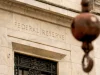 Tulisan Federal Reserve terpahat di fasad gedung batu dengan kait derek di depannya