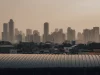 Deretan gedung pencakar langit Jakarta diselimuti kabut pada senja hari