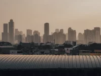 Deretan gedung pencakar langit Jakarta diselimuti kabut pada senja hari