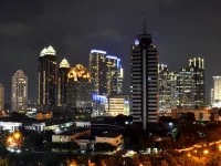 Ilustrasi gedung-gedung pencakar langit kawasan niaga SCBD yang menyala pada malam hari di Jakarta