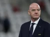 Presiden FIFA Gianni Infantino berjas gelap berdiri di pinggir lapangan stadion
