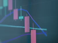 Grafik lilin harga saham bergerak turun pada layar monitor perdagangan