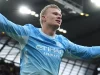 Erling Haaland merentangkan tangan merayakan gol Manchester City