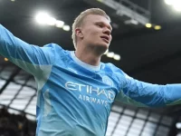 Erling Haaland merentangkan tangan merayakan gol Manchester City