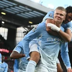 Erling Haaland merayakan gol sambil digendong rekan setim Manchester City di Anfield