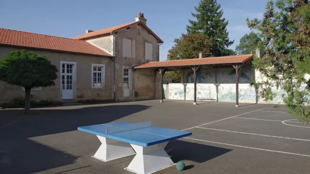 Halaman sekolah yang kosong dengan meja pingpong beton di Brux, Vienne, Prancis