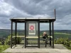 Ilustrasi seorang perempuan duduk menunggu di halte bus tepi perbukitan, Yorkshire, Inggris